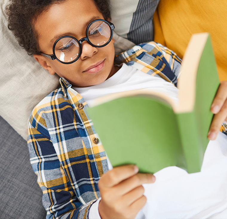 Elementary school child relaxing and reading a book